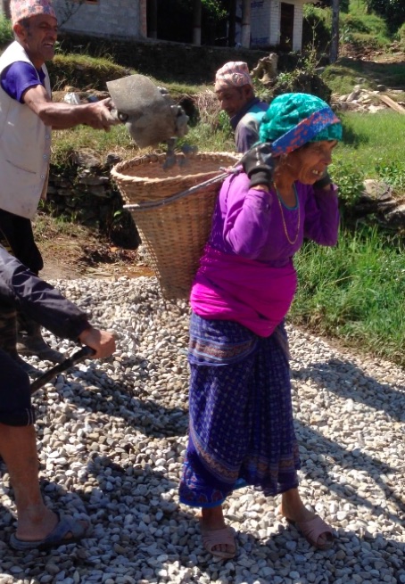 Man loading woman's basket with rocks to carry
