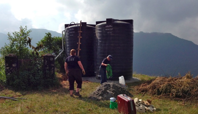 Piping together two upper tanks that will distribute water around the community.